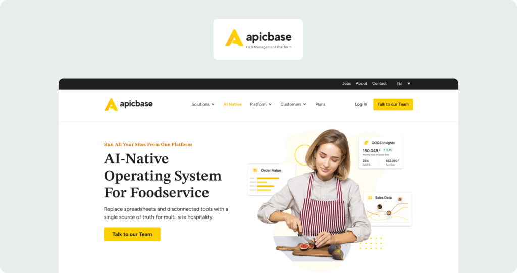 Apicbase homepage showing the hero section with headline "AI-Native Operating System For Foodservice" alongside a woman slicing food with COGS and sales data dashboards overlaid.