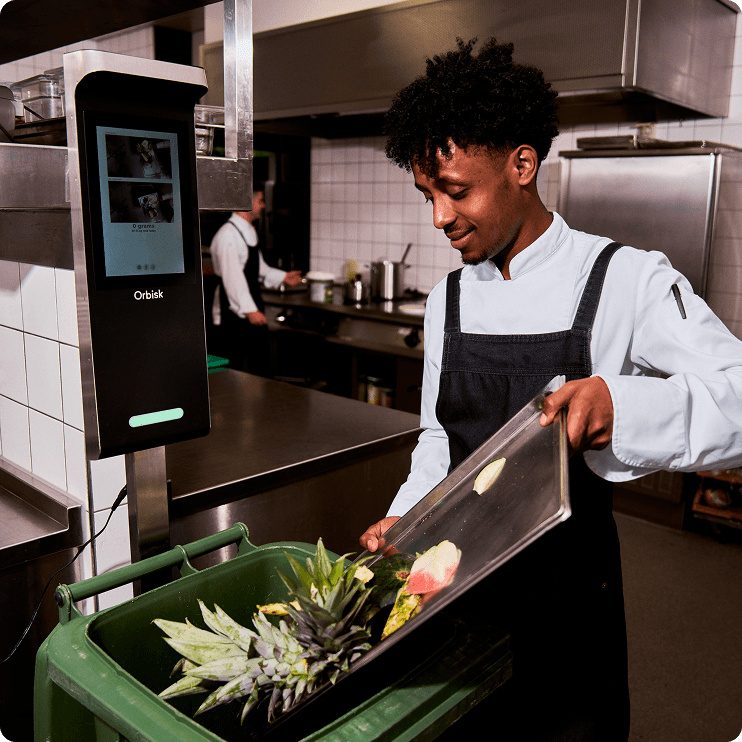orbisk-chef-scanning-food-waste Kok die met het Orbisk-apparaat etensresten scant voordat ze worden weggegooid, in een professionele keuken