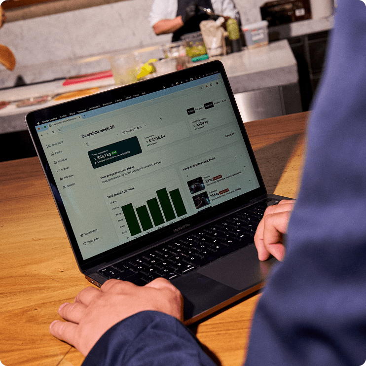 orbisk-dashboard-tablet-view Orbisk-dashboard voor voedselverspilling met een weekoverzicht op een laptop in een restaurantkeuken